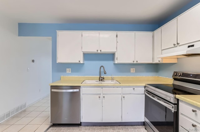 kitchen featuring white cabinetry, sink, light tile patterned floors, and appliances with stainless steel finishes