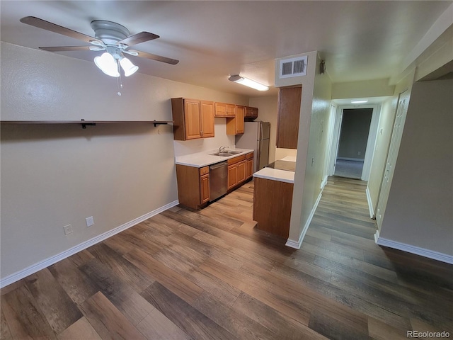 16359 W 10th Ave Unit Yy2, Golden, CO 80401 - kitchen with stainless steel dishwasher, freestanding refrigerator, light countertops, a ceiling fan, and wood finished floors