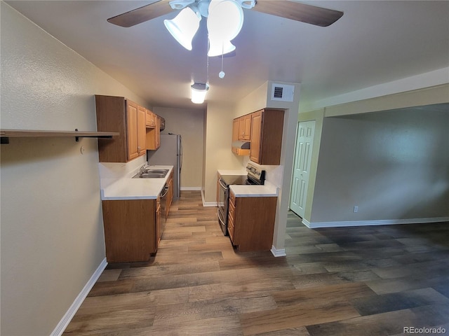 16359 W 10th Ave Unit Yy2, Golden, CO 80401 - kitchen with stainless steel appliances, a ceiling fan, exhaust hood, dark wood-style flooring, and light countertops