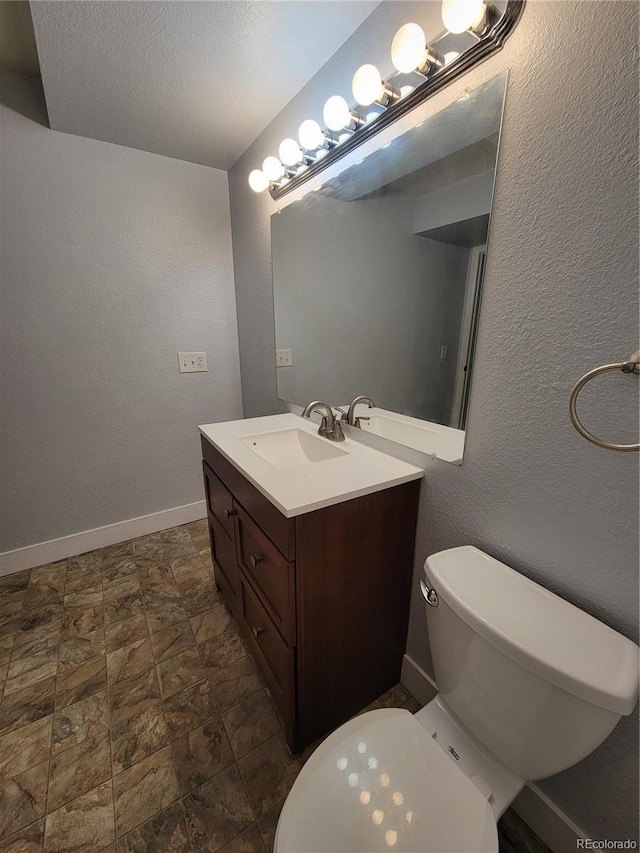 16359 W 10th Ave Unit Yy2, Golden, CO 80401 - half bathroom with vanity, stone finish floors, and a textured wall