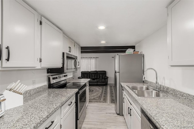 kitchen featuring white cabinets, appliances with stainless steel finishes, and a sink