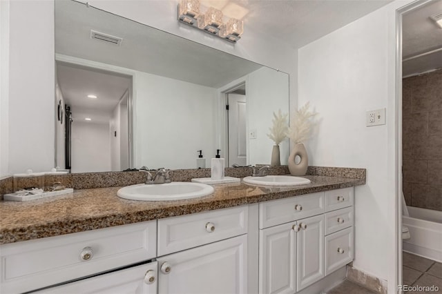 full bathroom featuring tile patterned floors, double vanity, visible vents, and a sink