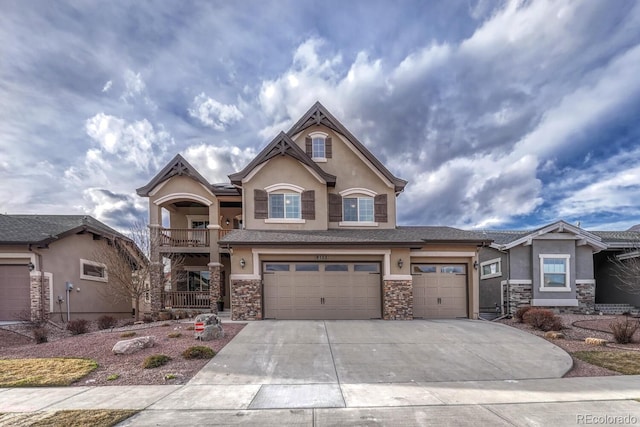 6132 Cubbage Dr, Colorado Springs, CO 80924 - view of front of property featuring concrete driveway, stucco siding, an attached garage, stone siding, and a balcony
