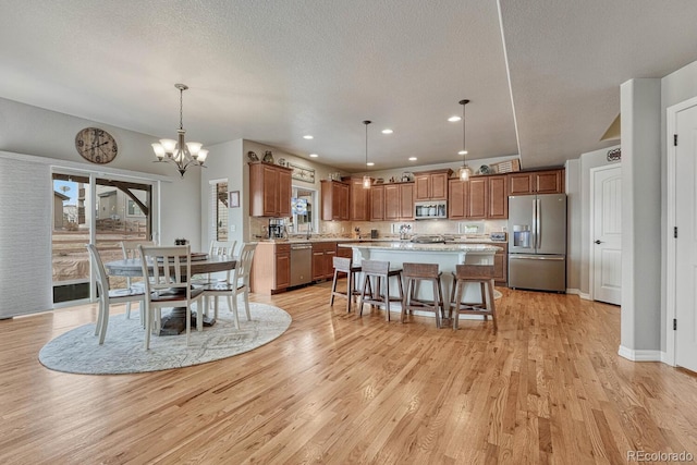 6132 Cubbage Dr, Colorado Springs, CO 80924 - dining room featuring a textured ceiling, baseboards, light wood-style floors, recessed lighting, and an inviting chandelier