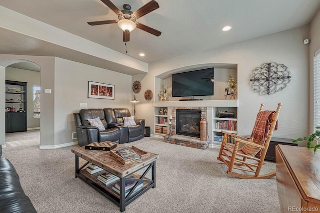 6132 Cubbage Dr, Colorado Springs, CO 80924 - carpeted living area with baseboards, ceiling fan, recessed lighting, a stone fireplace, and arched walkways
