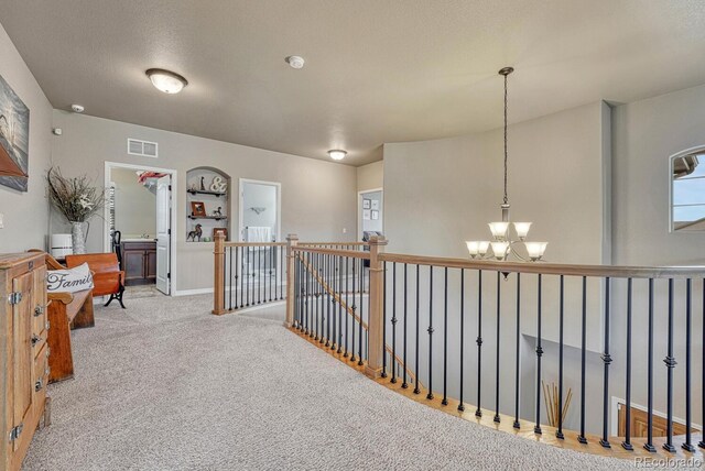 6132 Cubbage Dr, Colorado Springs, CO 80924 - corridor featuring an upstairs landing, carpet flooring, a textured ceiling, visible vents, and a notable chandelier