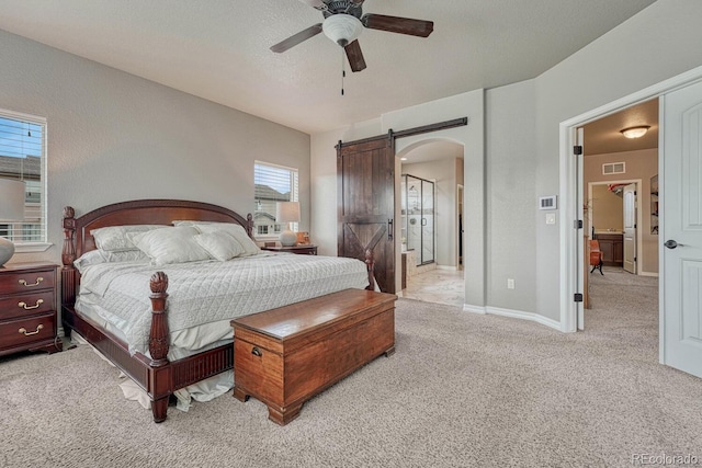 6132 Cubbage Dr, Colorado Springs, CO 80924 - carpeted bedroom featuring visible vents, baseboards, a ceiling fan, arched walkways, and a barn door