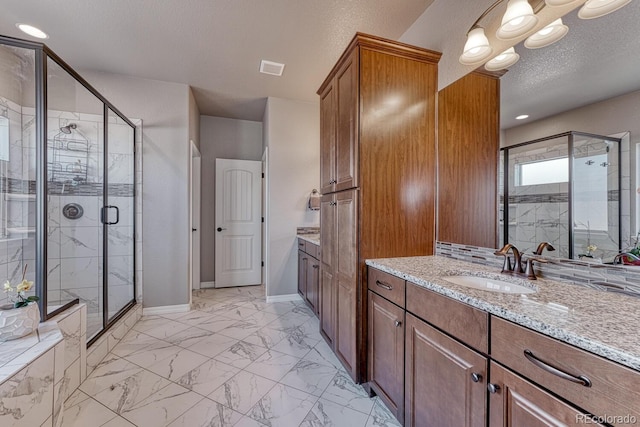 6132 Cubbage Dr, Colorado Springs, CO 80924 - full bathroom with vanity, baseboards, a textured ceiling, marble finish floor, and a stall shower