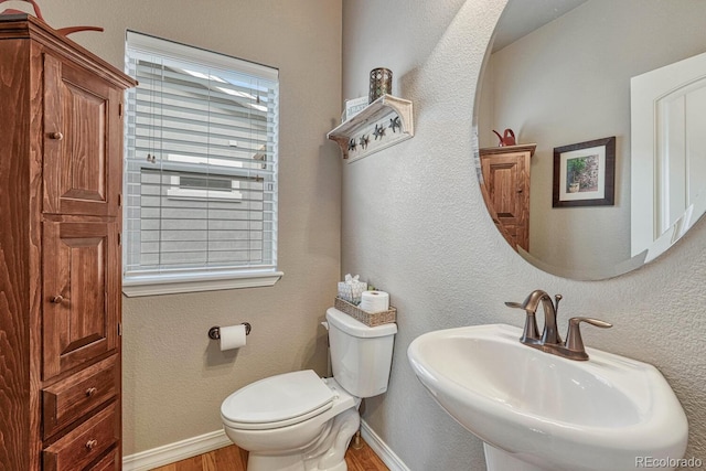 6132 Cubbage Dr, Colorado Springs, CO 80924 - half bath with toilet, a textured wall, baseboards, a sink, and wood finished floors