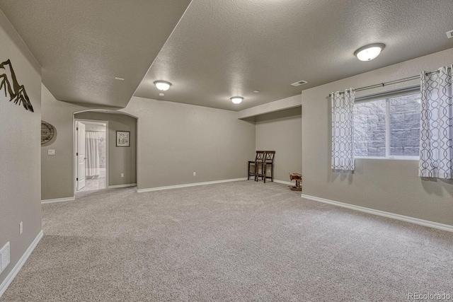 6132 Cubbage Dr, Colorado Springs, CO 80924 - basement with carpet, baseboards, a textured ceiling, arched walkways, and visible vents