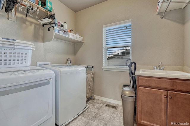 6132 Cubbage Dr, Colorado Springs, CO 80924 - clothes washing area with a sink, separate washer and dryer, baseboards, visible vents, and cabinet space