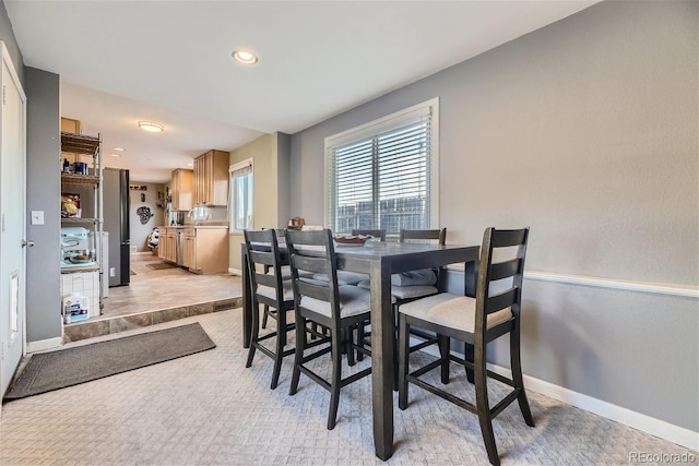 dining space with recessed lighting, baseboards, and light carpet