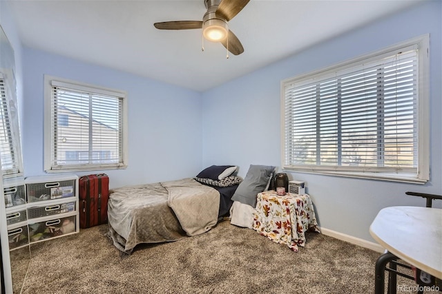 bedroom with baseboards, multiple windows, ceiling fan, and carpet flooring