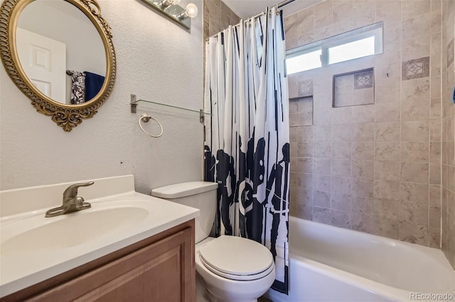 bathroom featuring vanity, toilet, a textured wall, and shower / bath combo with shower curtain