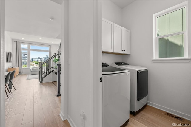 16722 Shoshone St, Broomfield, CO 80023 - laundry area with independent washer and dryer, cabinet space, light wood-style flooring, and baseboards