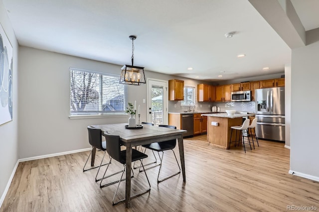 4620 E 135th Way, Thornton, CO 80241 - dining area featuring light wood-type flooring, baseboards, recessed lighting, and a chandelier