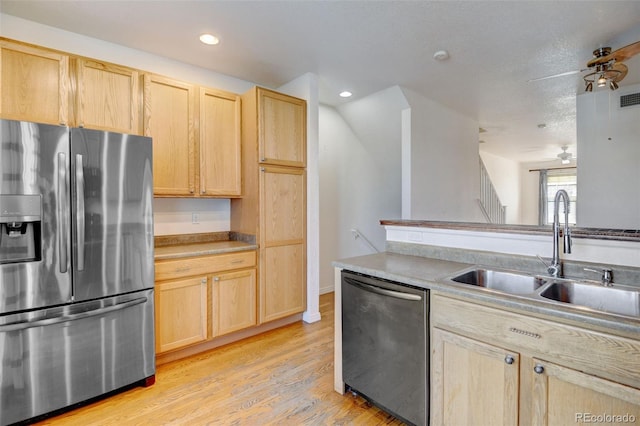 kitchen featuring stainless steel appliances, light brown cabinetry, and sink