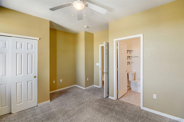 unfurnished bedroom featuring a closet, ceiling fan, light carpet, and ensuite bath