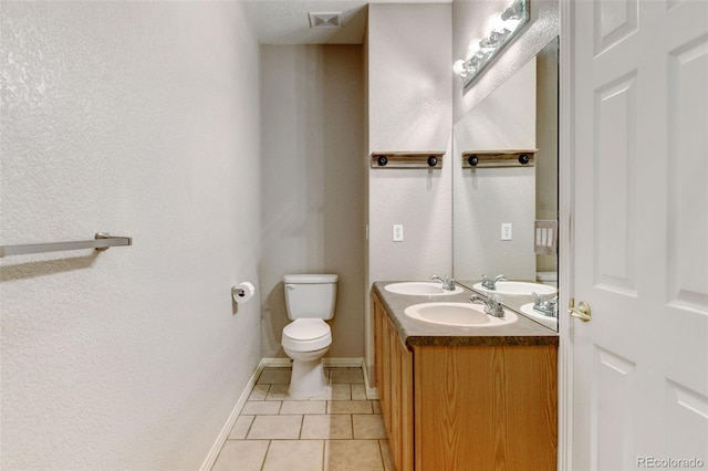 bathroom featuring vanity, tile patterned floors, and toilet