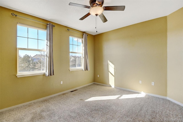 carpeted spare room with ceiling fan