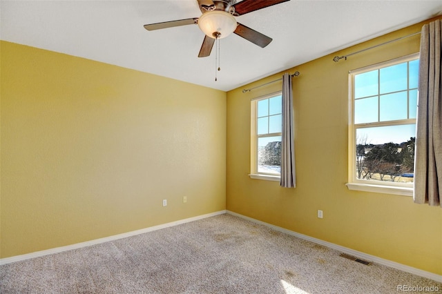 empty room featuring ceiling fan and carpet