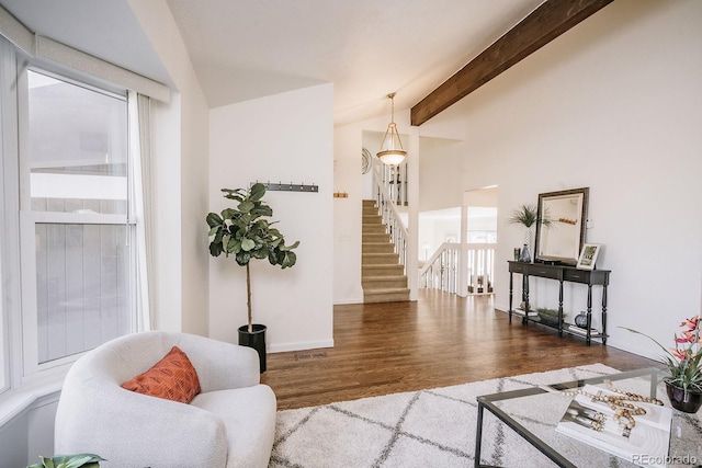 living room featuring vaulted ceiling with beams, wood finished floors, and stairs