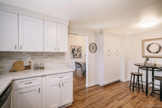 kitchen featuring decorative backsplash, stainless steel dishwasher, wood finished floors, and white cabinets