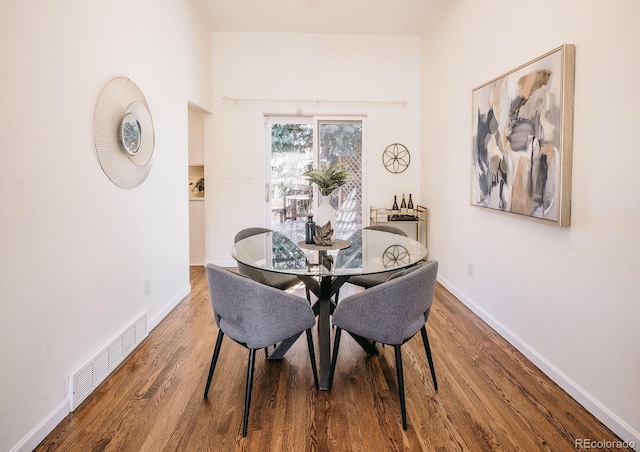 dining room featuring visible vents, baseboards, and wood finished floors