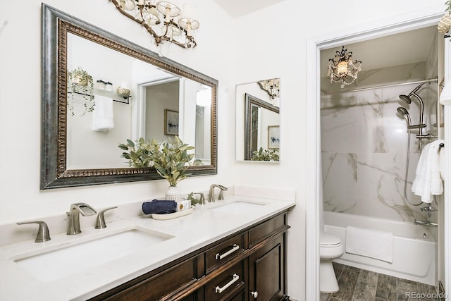 full bathroom with double vanity, toilet, wood finished floors, and a sink