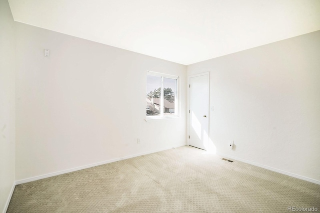 spare room with visible vents, baseboards, and light colored carpet