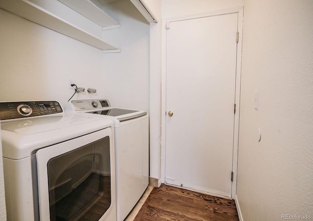 laundry room with washing machine and clothes dryer, laundry area, and wood finished floors