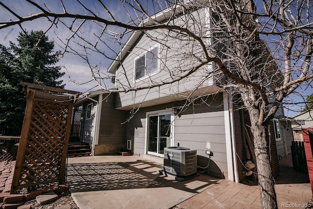 rear view of property featuring central air condition unit and a patio area