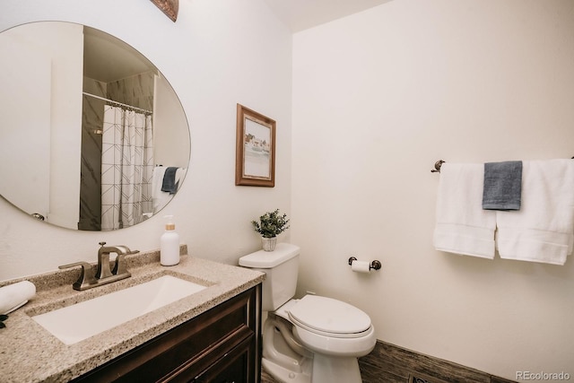 bathroom featuring vanity, a shower with shower curtain, toilet, and wood finished floors