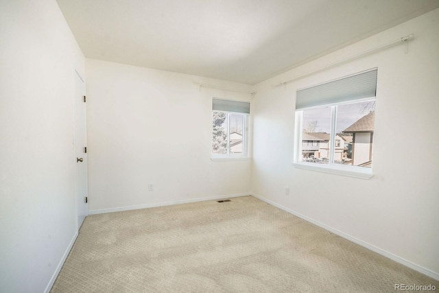 spare room featuring baseboards and carpet floors