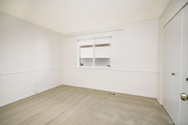 spare room with baseboards, visible vents, and carpet floors