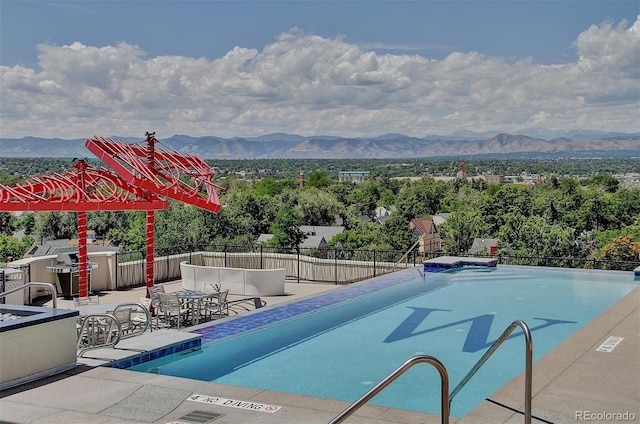 view of swimming pool featuring a mountain view and a patio area