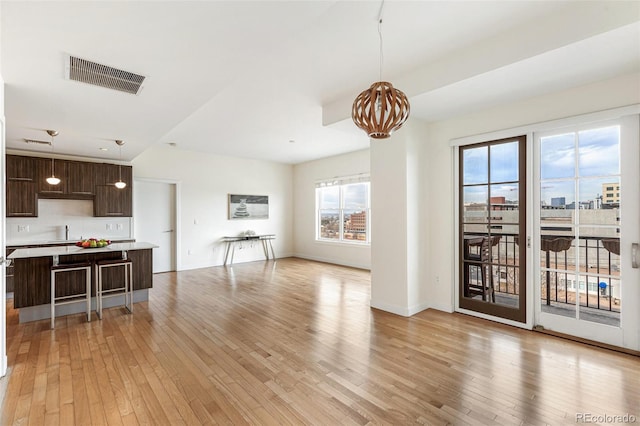 living room with sink, a chandelier, and light wood-type flooring