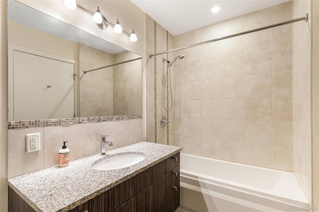 bathroom with vanity, decorative backsplash, and tiled shower / bath combo