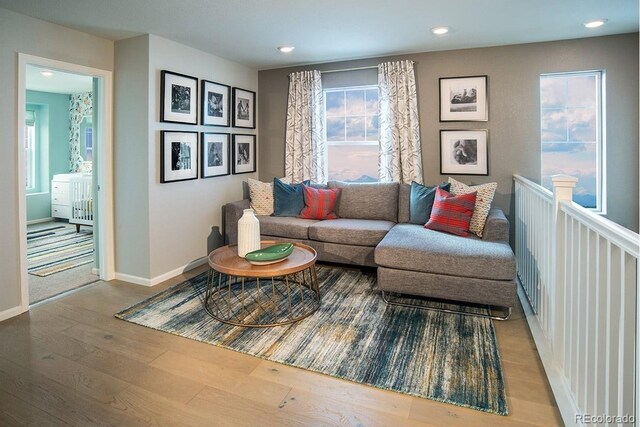 living room with light hardwood / wood-style floors and a healthy amount of sunlight