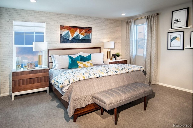 bedroom featuring carpet floors, baseboards, and brick wall