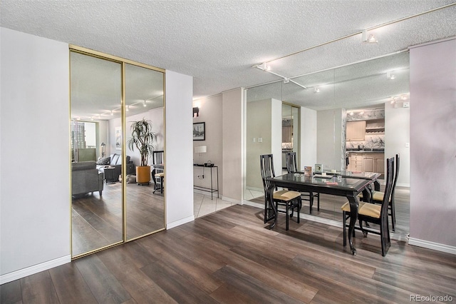 dining area with a textured ceiling, dark hardwood / wood-style floors, and rail lighting