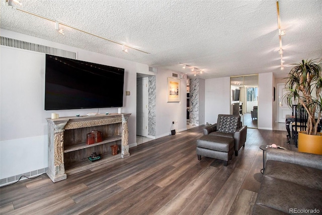 living room featuring hardwood / wood-style floors, a textured ceiling, and track lighting