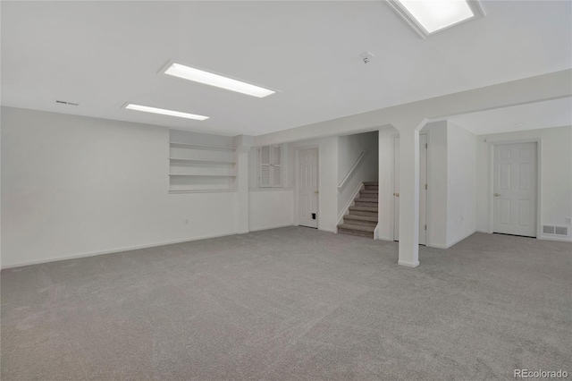6054 W Adriatic Pl, Lakewood, CO 80227 - basement featuring light colored carpet, stairway, and baseboards