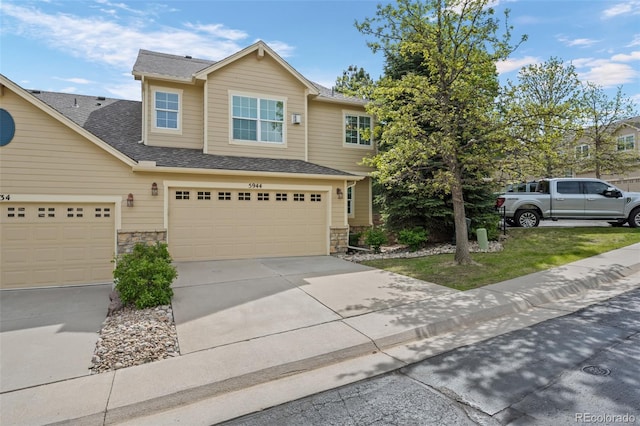 5944 S Yank Ct, Littleton, CO 80127 - view of front facade featuring stone siding, concrete driveway, an attached garage, and a shingled roof