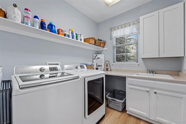 5944 S Yank Ct, Littleton, CO 80127 - laundry area featuring separate washer and dryer, light wood finished floors, and cabinet space