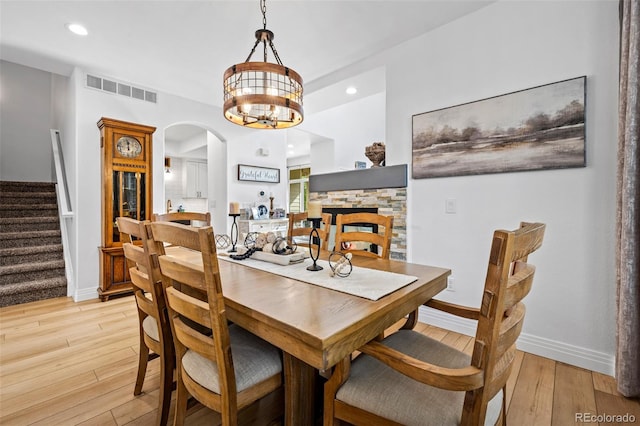 5944 S Yank Ct, Littleton, CO 80127 - dining room with light wood-style flooring, stairway, arched walkways, a chandelier, and baseboards