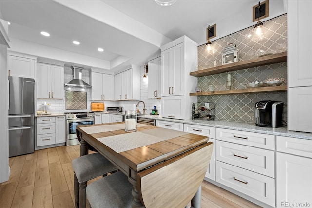 5944 S Yank Ct, Littleton, CO 80127 - kitchen featuring stainless steel appliances, wall chimney exhaust hood, tasteful backsplash, recessed lighting, and white cabinetry