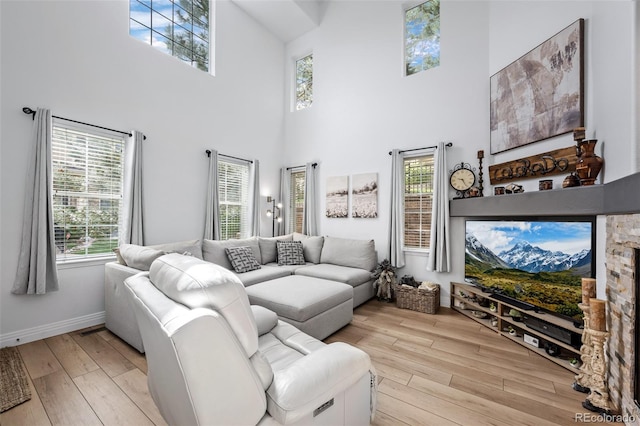 5944 S Yank Ct, Littleton, CO 80127 - living room featuring light wood finished floors, a towering ceiling, and baseboards