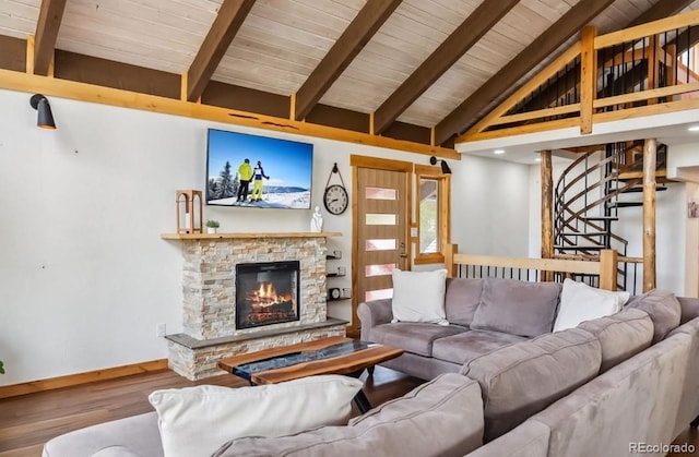 142 High Point Dr, Breckenridge, CO 80424 - living room featuring wood finished floors, beamed ceiling, baseboards, a stone fireplace, and wooden ceiling