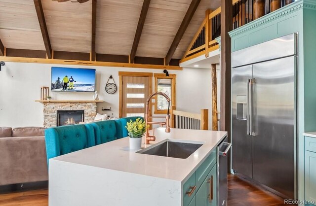 142 High Point Dr, Breckenridge, CO 80424 - kitchen with stainless steel appliances, a sink, dark wood-style floors, light countertops, and a stone fireplace